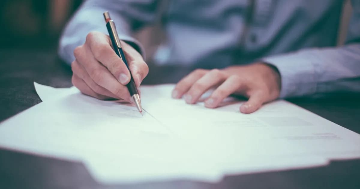 Documento de testamento sobre escritorio de notaría con pluma y sello